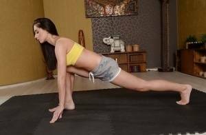 Cute brunette babe Aruna Aghora doing yoga in shorts and bare feet on girlsfans.net
