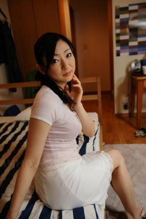 Slender mature Japanese woman Emiko Koike bends over to pose in white dress - Japan on girlsfans.net