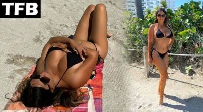 Claudia Romani Shows Off Her Curves on the Beach on girlsfans.net