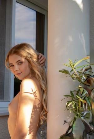 Young blonde Chanel Fenn shows her sexy ass while getting naked in a garden on girlsfans.net